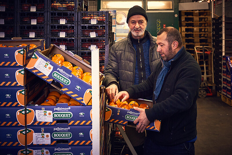 Einkäufer im Großmarktgeschehen Einkäufer prüft Orangen in der Großmarkthalle